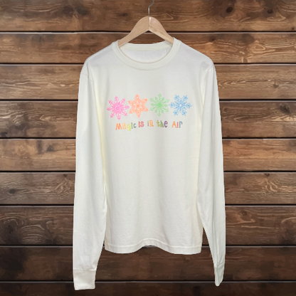 Pastel, glitter snowflakes in a row. Metallic gold outlined words. Magic is in the Air in Pastel glitter colors.